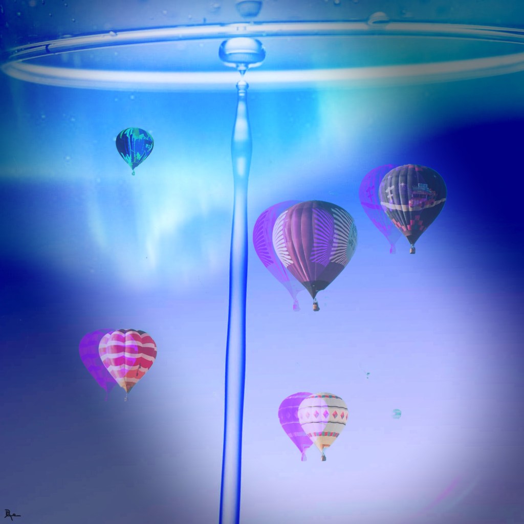 Surreal image of hot air balloons, miniaturized, seemingly floating in a giant glass of water with a droplet flowing up against gravity. 